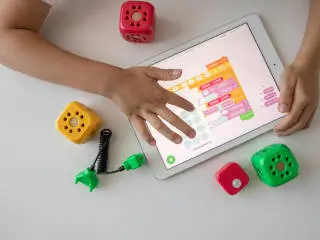 Child using block based programming software on a tablet